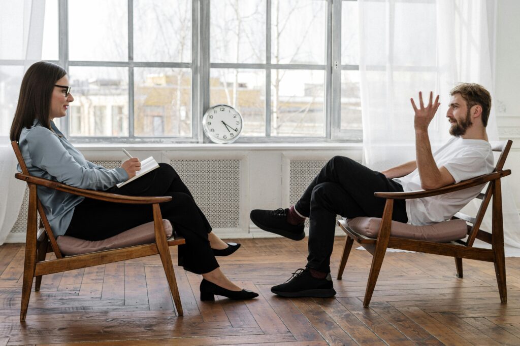 1 to 1 coaching A therapist engaging in a counseling session with a male patient to support mental health.