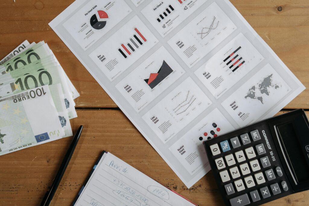 financial tracker templates Euro banknotes, graphs, and calculator on a wooden table setup for financial analysis.